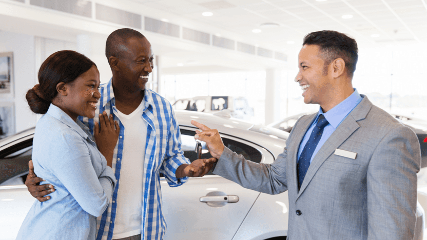 A couple receiving the keys to their new car
