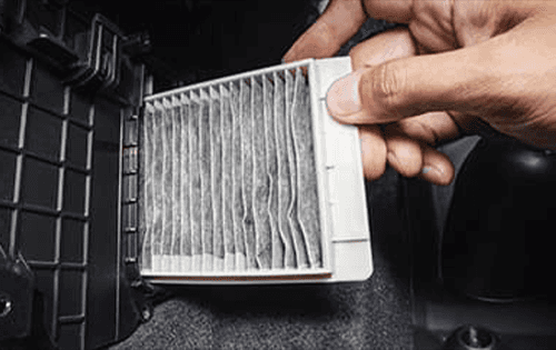 Service technician replacing cabin air filter.
