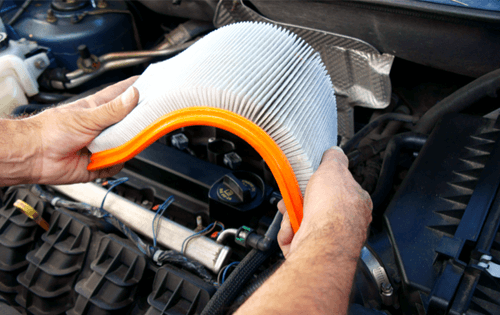Service technician replacing engine air filter.