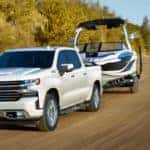 2021 white Chevrolet Silverado 1500 towing a boat