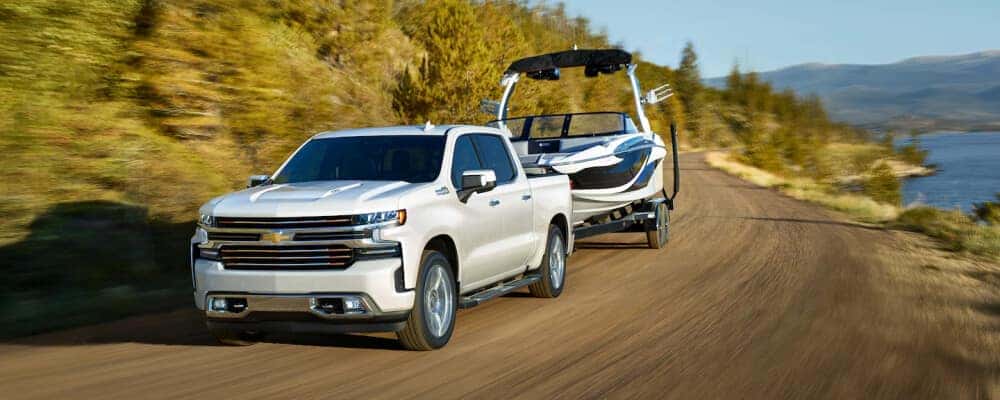 2021 white Chevrolet Silverado 1500 towing a boat