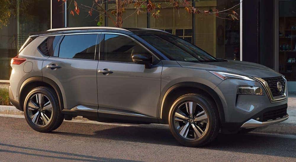 A grey 2021 Nissan Rogue Sport is parked on a city street.