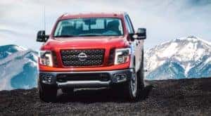 A red 2018 Nissan Titan is parked in front of snow covered mountains.