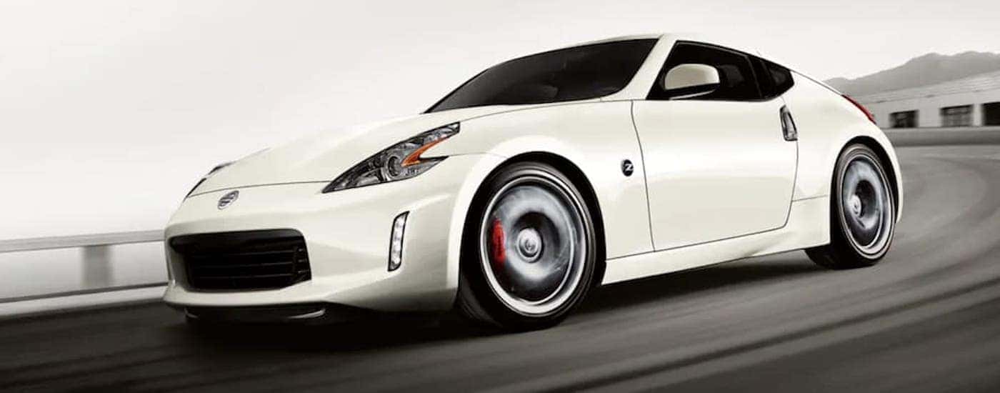 A white 2020 Nissan 370z is driving around a corner on a racetrack.