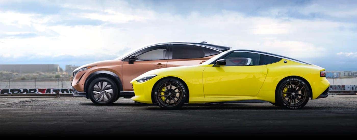 A bronze 2022 Nissan Ariya is shown passing a yellow 2022 Nissan Z after visiting a Louisville electric car dealer.