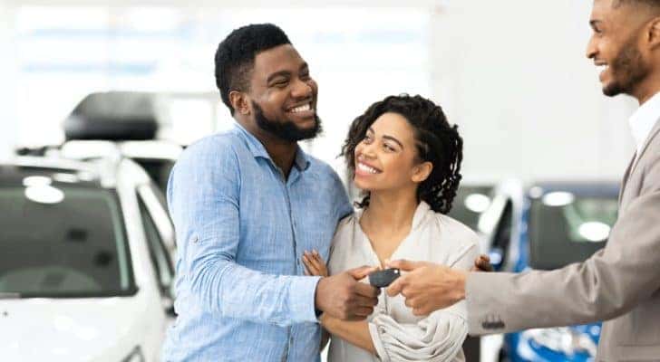 A couple is shown inside a showroom after finding the right Louisville Nissan dealers.