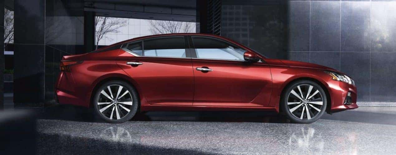 A red 2021 Nissan Altima is shown from the side parked in a gallery after winning a 2021 Nissan Altima vs 2022 Chevy Malibu comparison.