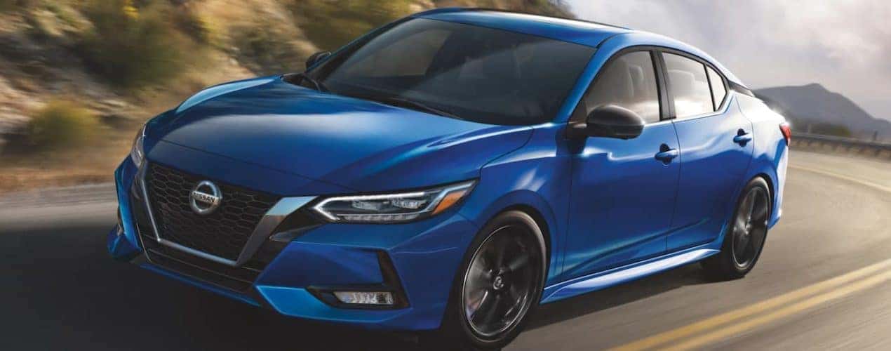 A blue 2022 Nissan Sentra is shown from the front driving on an open road.