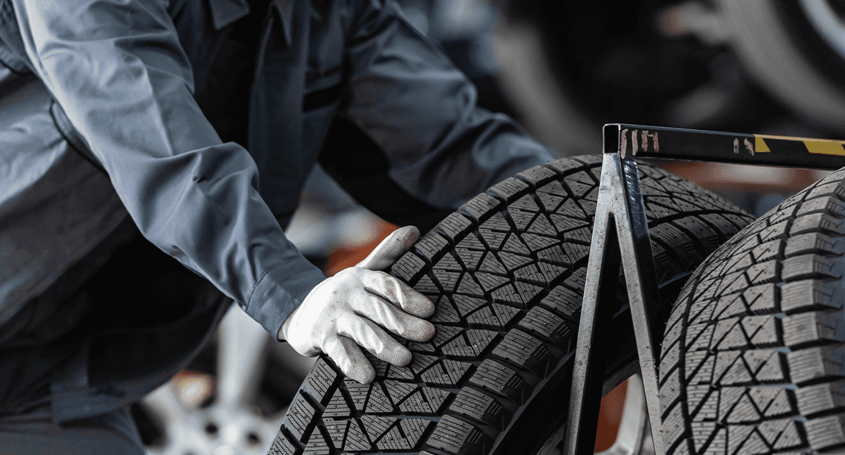 Service technician pulling a tire from a rack.