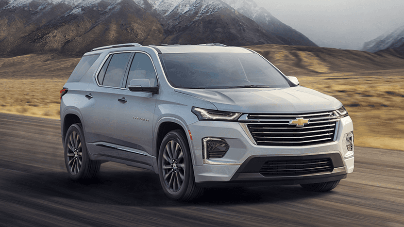 2022 Chevy Traverse Premier driving on the road in front of some mountains
