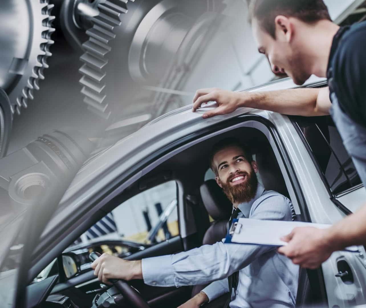 A man inside a car smiles at another man holding a clipboard, suggesting professional advice. Background shows large mechanical gears, implying parts and automotive service.