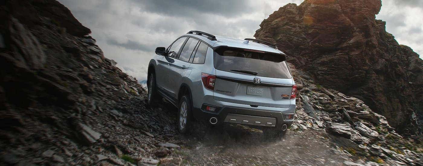 A grey 2022 Honda Passport TrailSpor is shown crawling up a rocky trail.