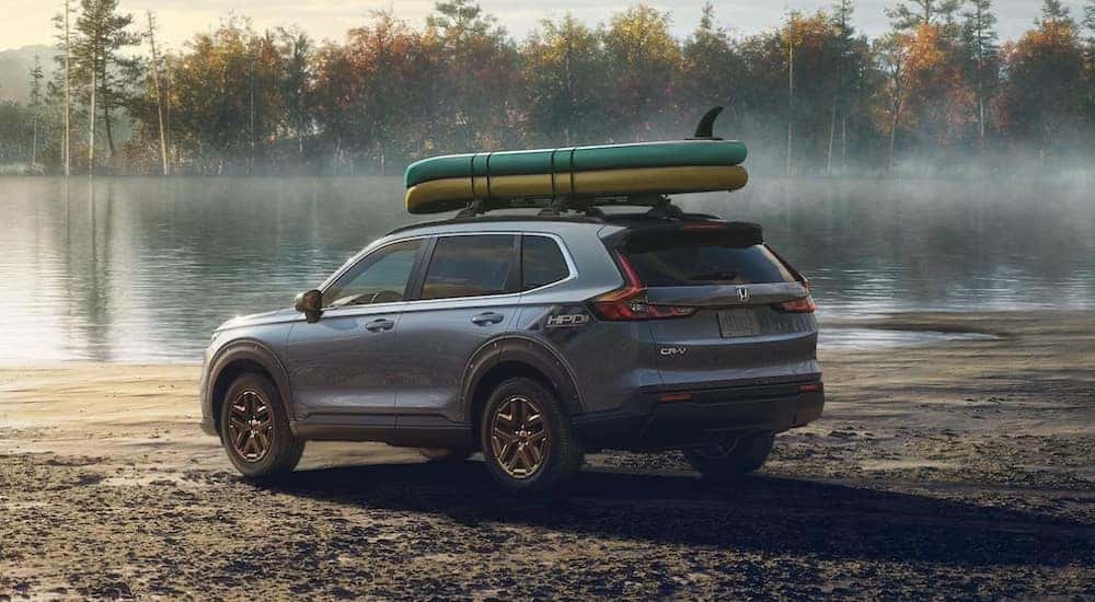 A gray 2023 Honda CR-V EX with the HPD Package is shown parked near a lake.