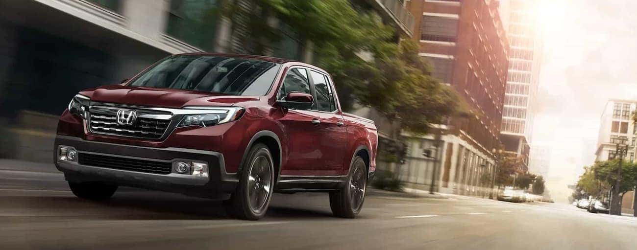A red 2020 Honda Ridgeline RTL-E is shown on a test drive near a used Honda dealer in Oklahoma City.