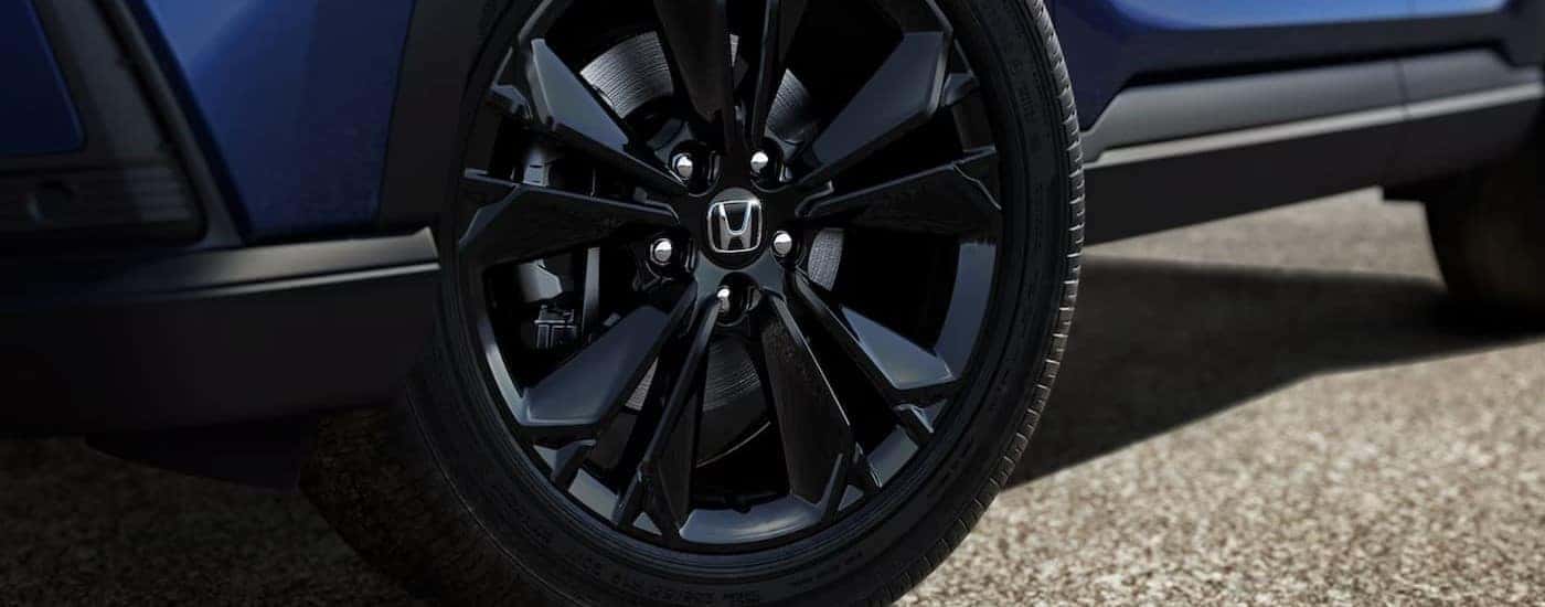 A close-up of the wheel on a blue 2024 Honda CR-V is shown.