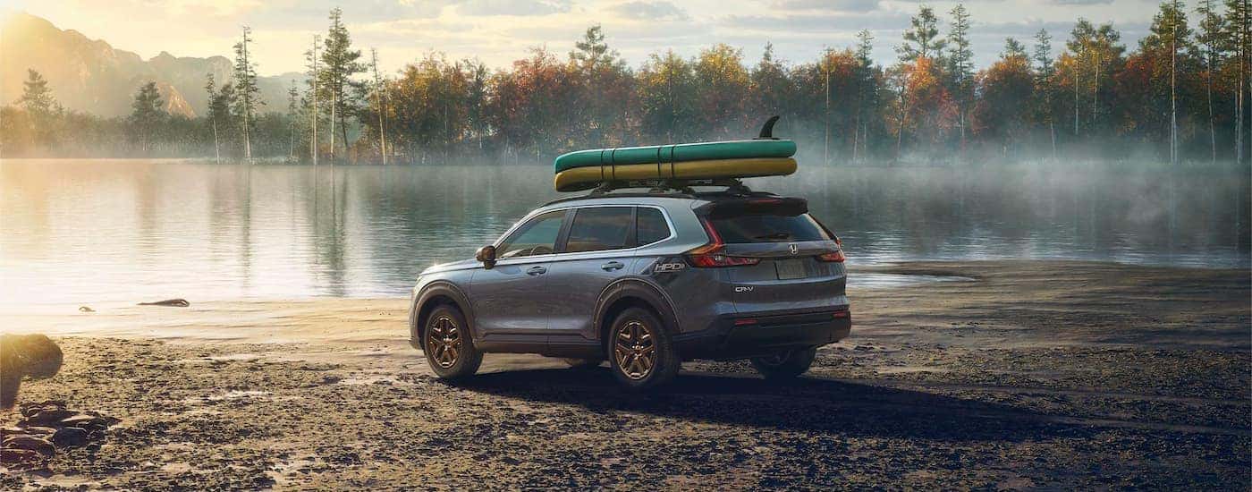 A gray 2024 Honda CR-V HPD-EX is shown parked near a lake.