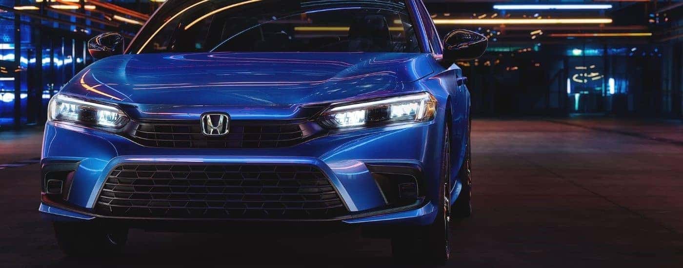 A blue 2024 Honda Civic for sale is shown from the front.