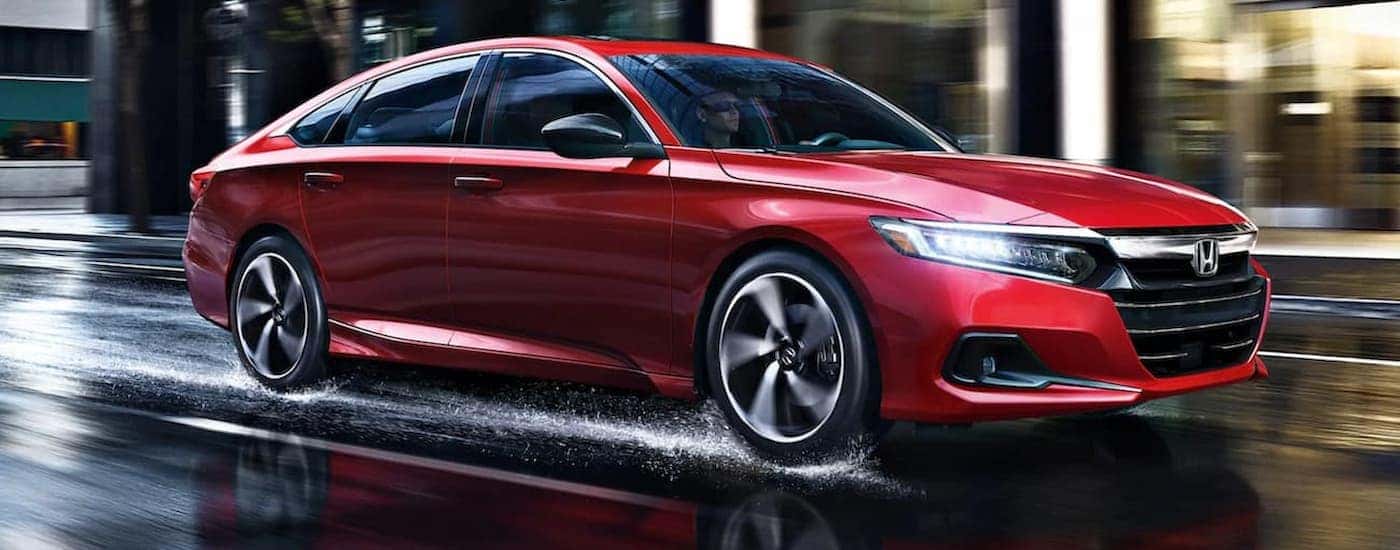 A red 2021 Honda Accord is shown driving on a wet road.