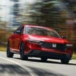 A red 2024 Honda Accord Sport-L Hybrid driving toward the camera.