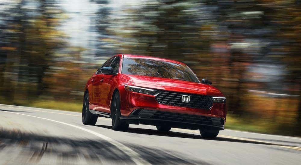 A red 2024 Honda Accord Sport-L Hybrid driving toward the camera.