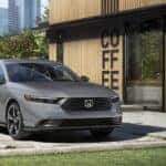 A gray 2024 Honda Accord Sport Hybrid is shown parked near a coffee shop after viewing a Honda Accord for sale near Moore.