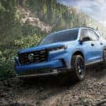 A blue 2025 Honda Pilot TrailSport is shown from the front at an angle after leaving a Honda dealer near Blanchard.