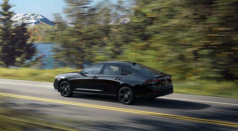 A black 2023 Honda Accord is shown from the side.