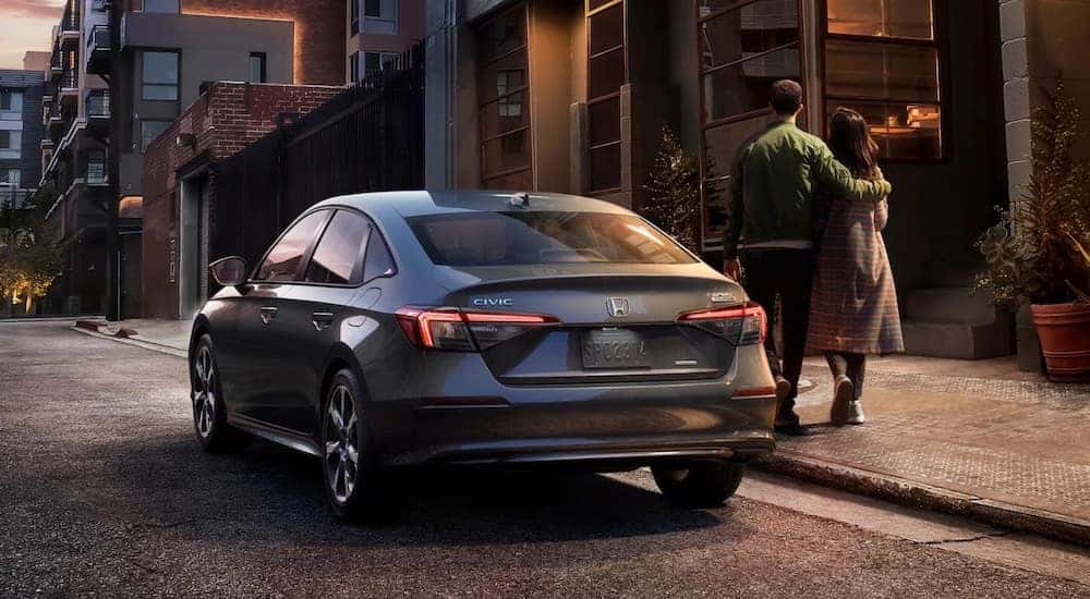 A grey 2023 Honda Civic Sedan is shown from the rear at an angle after leaving a used Honda dealer.