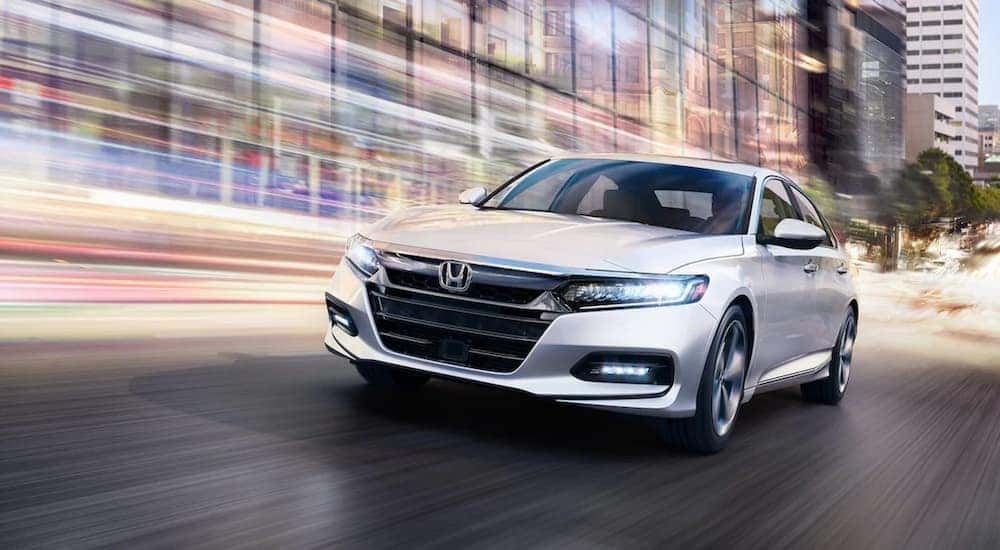 A white 2018 Honda Accord Touring is shown driving on a city street.