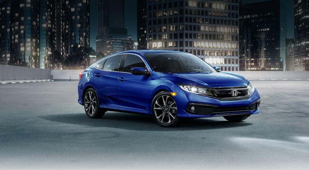 A popular certified pre-owned Honda, a blue 2021 Honda Civic, is shown parked at night.
