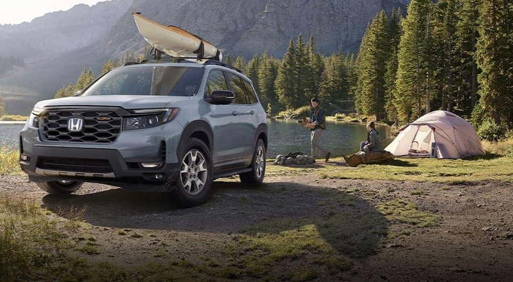 A gray 2023 Honda Passport TrailSport is shown parked on a campsite.
