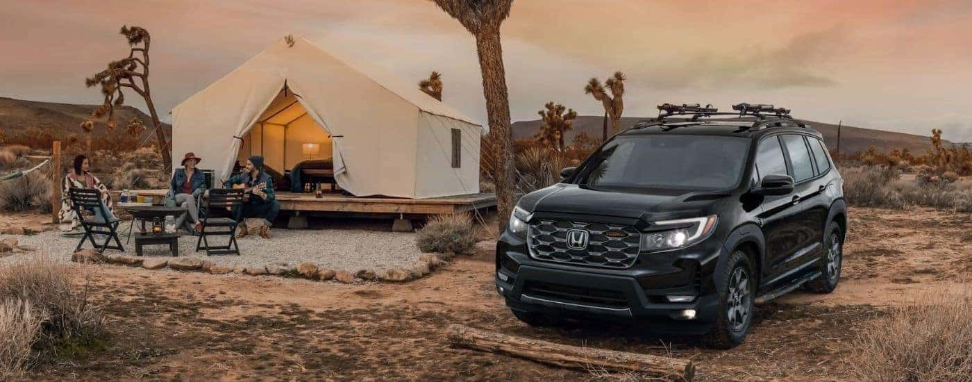 A black 2025 Honda Passport for sale parked at a luxury campsite.