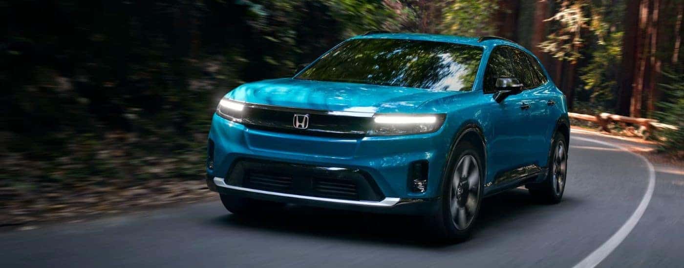A teal 2024 Honda Prologue Elite driving down the street