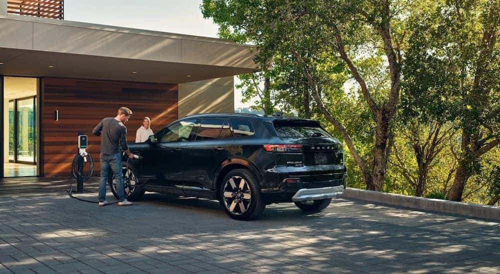 A black 2025 Honda Prologue is shown charging after visiting a "Honda dealer near me."