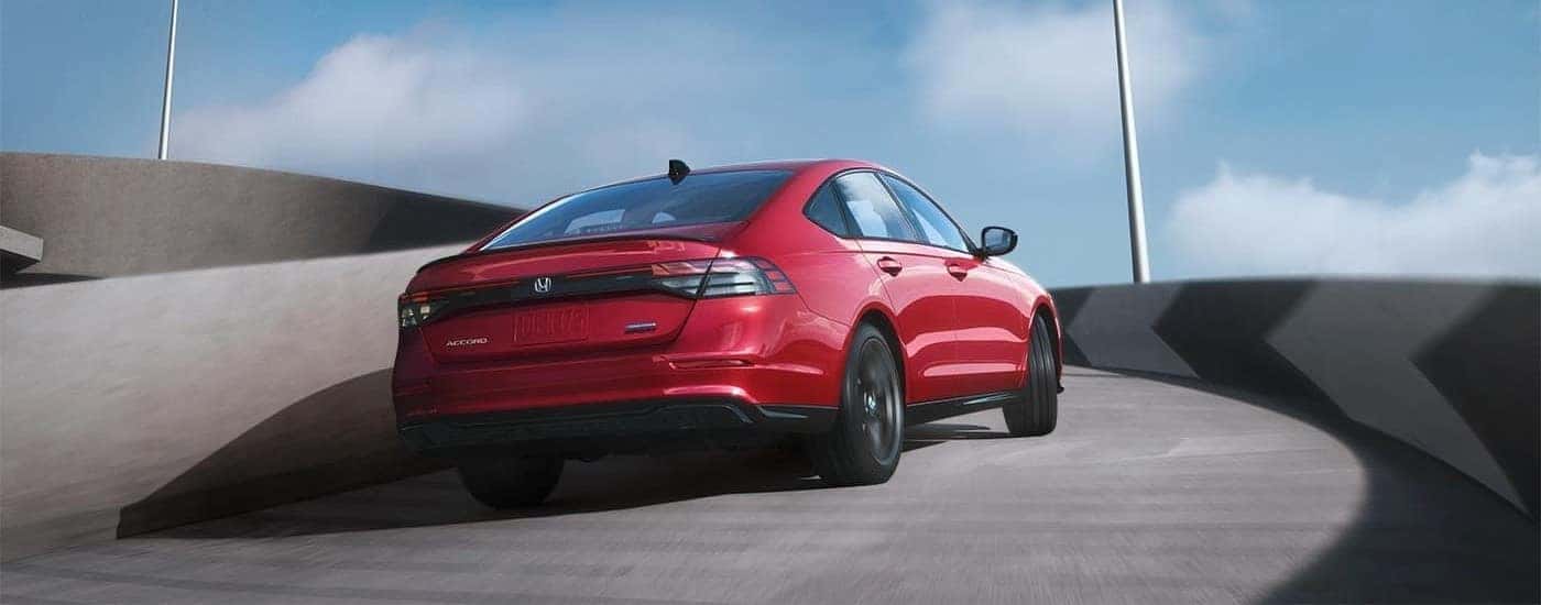 A red 2025 Honda Accord Hybrid Sport L driving on a ramp
