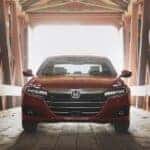 A red 2022 Honda Accord Touring is shown parked on a covered bridge.