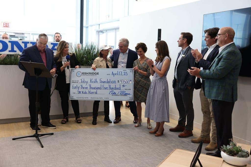 Eskridge Honda Team holding a check for the Toby Keith Kids Korral charity event.