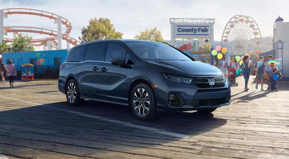 A black 2025 Honda Odyssey parked on a boardwalk.