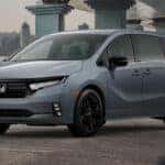 A grey 2025 Honda Odyssey for sale parked under a bridge.