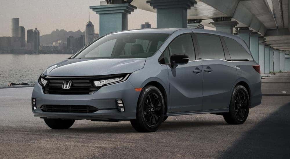 A grey 2025 Honda Odyssey for sale parked under a bridge.