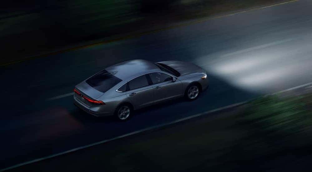 A silver 2024 Honda Accord driving at night.