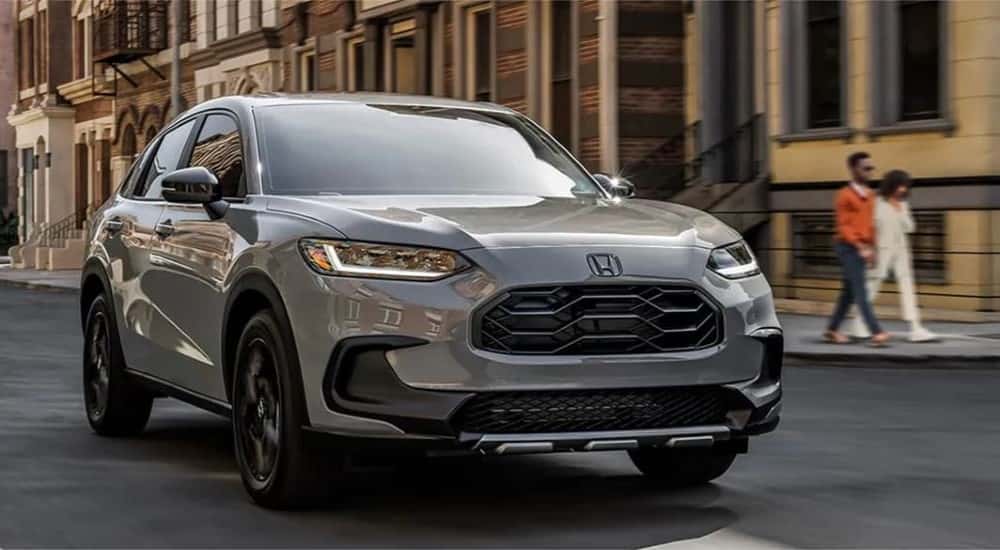 A gray 2023 Honda HR-V Sport driving in a city.