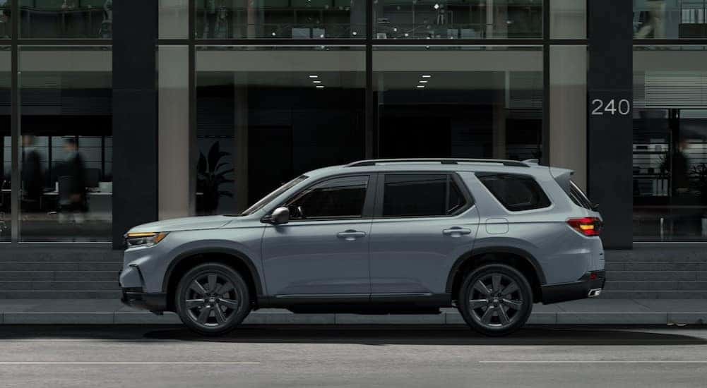 A gray 2025 Honda Pilot Trailsport parked on a city street.