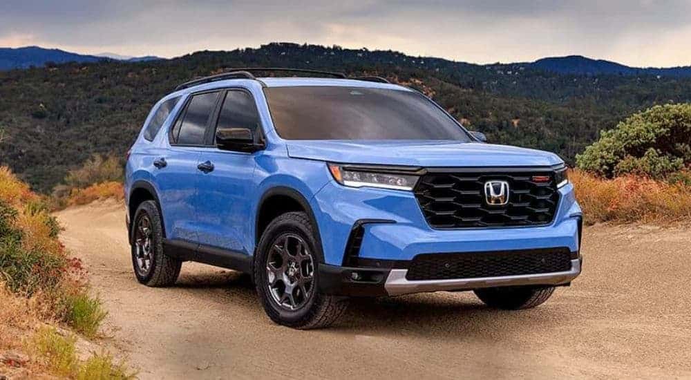 A blue 2025 Honda Pilot Trailsport parked off parked off-road