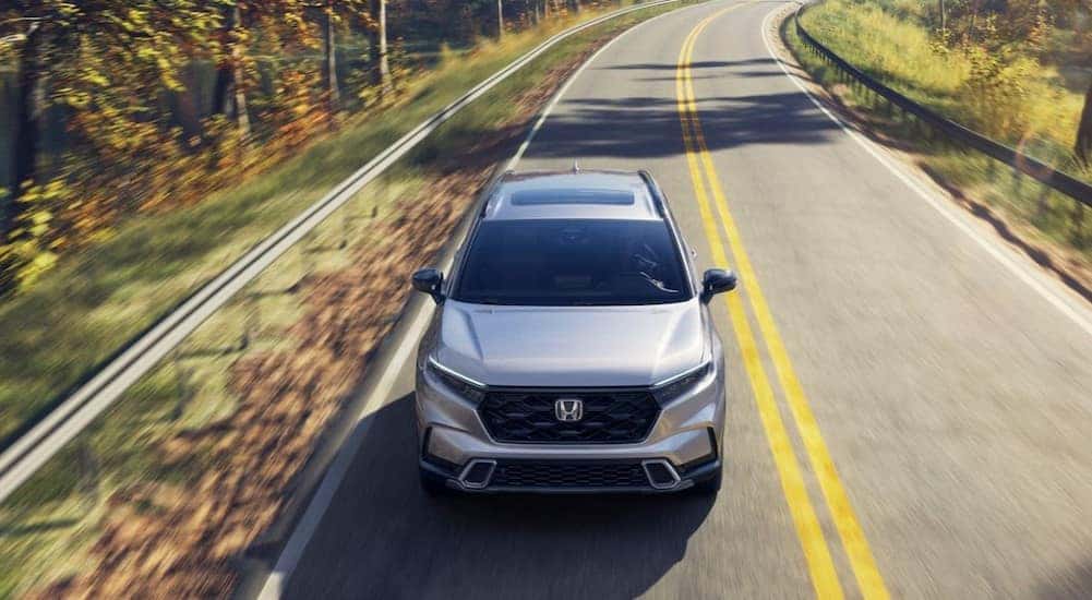 A silver 2026 Honda CR-V Sport Touring Hybrid driving after viewing a Honda CR-V for sale in Oklahoma City.