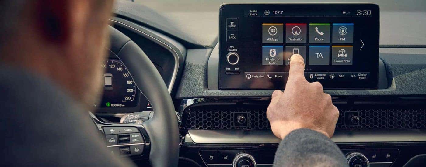 A man using the touch screen infotainment display in a 2025 Honda CR-V Hybrid