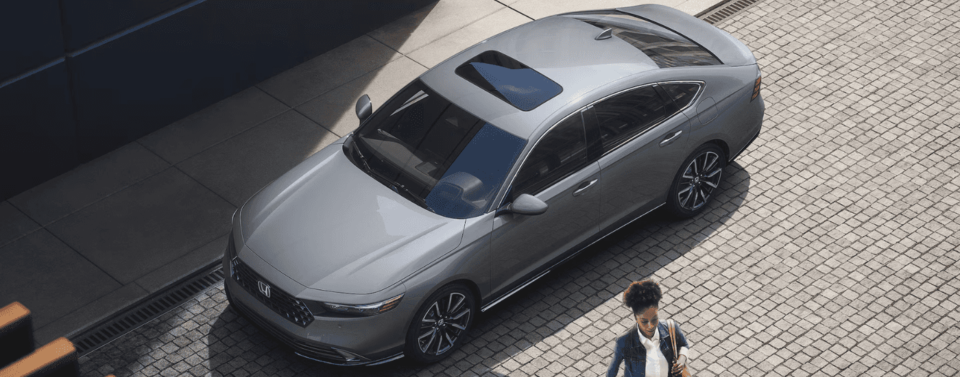 A person walks away from a silver 2025 Honda Accord Hybrid