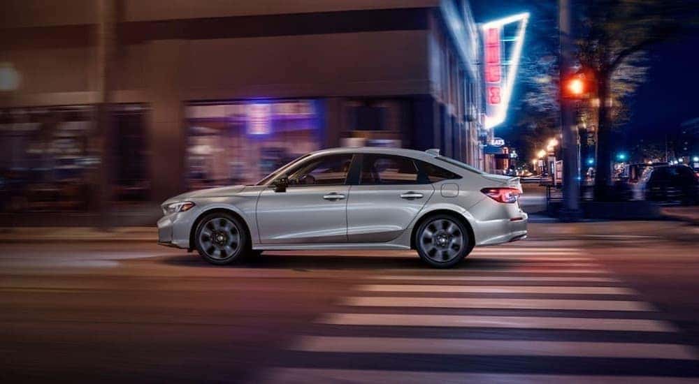 A silver 2025 Honda Civic driving in a city.