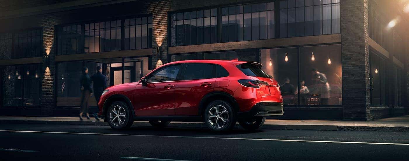 Side of a red 2026 Honda HR-V parked by a curb.