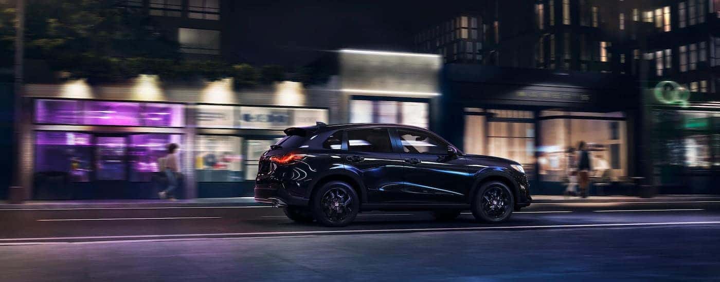 Rear of a black 2026 Honda HR-V driving down a road.